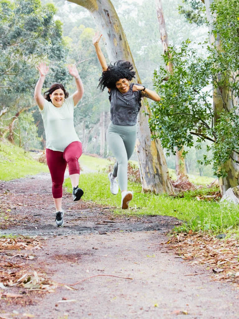 Two women jumping in the park
